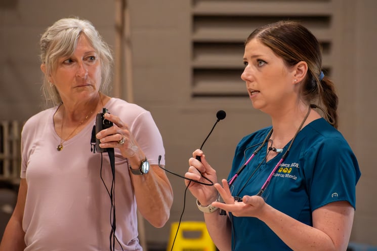 Kelsey Thompson talks oral health as she holds Julie Weisbrod's mic.