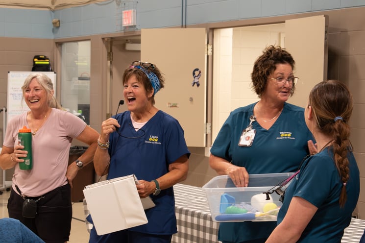 The Smiles on Wheels team, accompanied by Julie Weisbrod, offers oral health education before lunch.