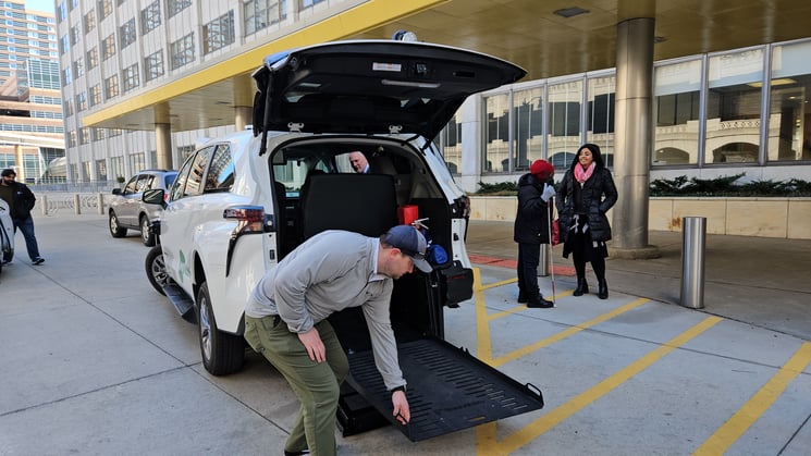 A safety driver unfolds the wheelchair lift from the shuttle.